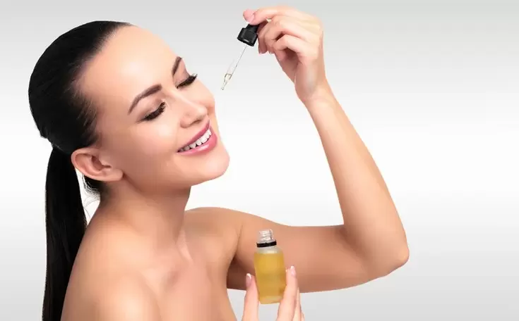 woman applying serum on her face